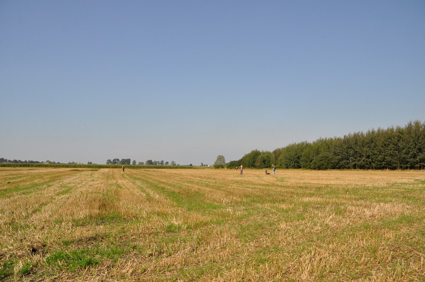 Archeologiczne badania nieinwazyjne, tzw. powierzchniówki, na terenie byłego pola bitwy z 1915 r. prowadzone przez Członków Zespołu Naukowego APP na polach i w lasach (fot. A. Zalewska) Krajobraz przedstawiający pole obok lasu, będące terenem dawnego pola bitwy z 1915 roku. To tutaj Członkowie Zespołu Naukowego APP prowadzą archeologiczne badania nieinwazyjne, tzw. powierzchniówki. Zdjęcie autorstwa A. Zalewskiej.