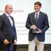 Od lewej stoją przedstawiciel Fundatora Nagrody NCN 2017, prezes Jastrzębskiej Spółki Węglowej Daniel Ozon oraz laureat Nagrody NCN 2017 w obszarze nauk ścisłych i technicznych, dr hab. Adam Rycerz na scenie po wręczeniu statuetki