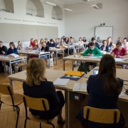 Dwie pracownice Narodowego Centrum Nauki siedzą naprzeciw uczestników warsztatów dla wnioskodawców. Uczestnicy warsztatów czytają materiały warsztatowe.