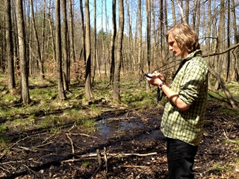 Łukasz Banaszek stoi w lesie, zajęty rejestracją form terenowych