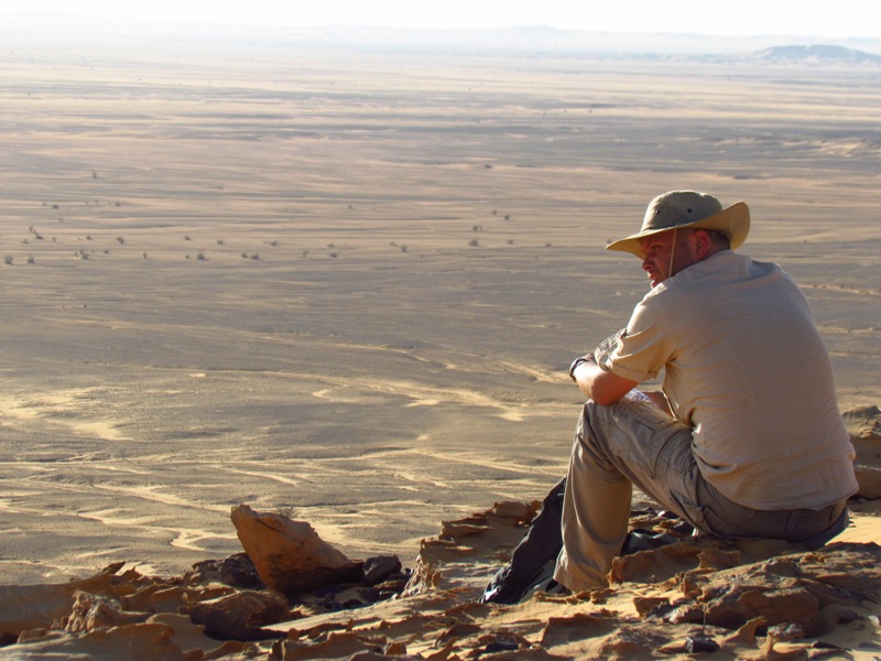 Mężczyzna w kapeluszu siedzi na wzniesieniu górującym nad Basenem Affad