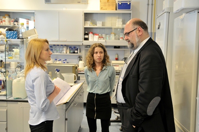 Grzegorz Węgrzyn rozmawia w laboratorium z dwiema badaczkami