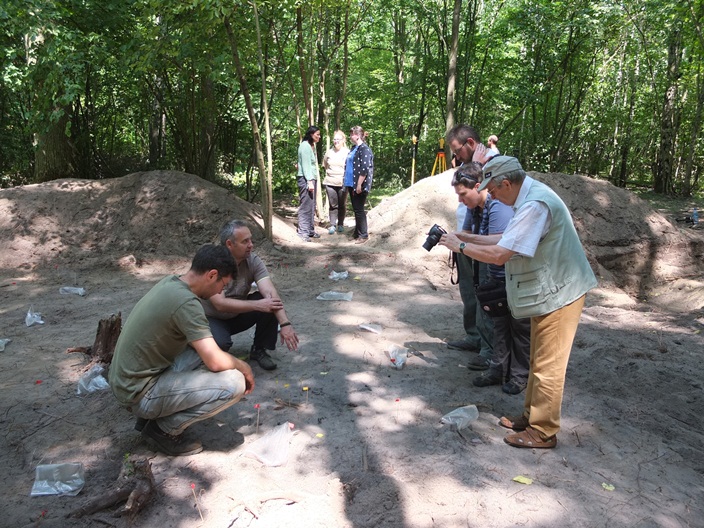 Członkowie Zespołu APP w trakcie badań wykopaliskowych na tzw. ziemi niczyjej w Puszczy Bolimowskiej prezentują bieżące wyniki zainteresowanym. Zdjęcie autorstwa J. Czarneckiego